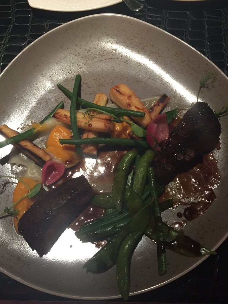 A plate of an assortment of vegetables and lamb