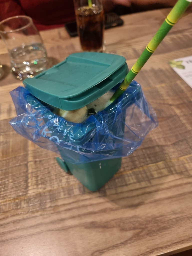 A cocktail in a mini plastic wheelie bin