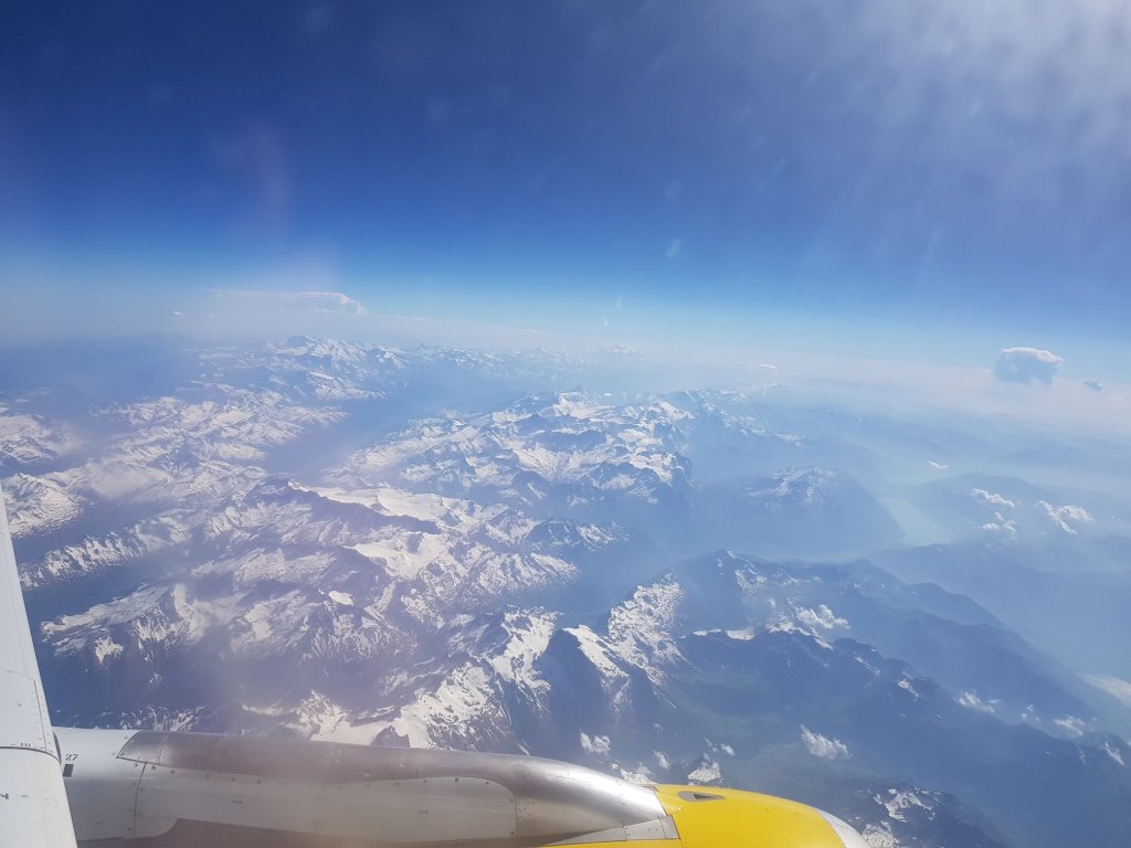The view of snow capped mountains out of a plane window